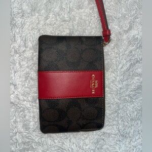 Coach bag with red wrist strap